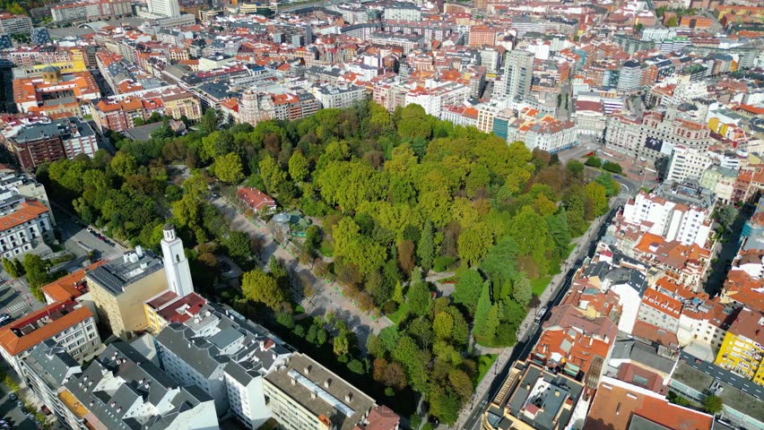 Aerial view of Oviedo, Spain, showcasing its historic architecture, bustling streets, and the iconic cathedral under clear autumn skies. A vibrant European city scene.