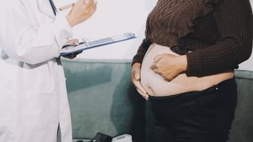 doctor attentively listening pregnant woman's belly - Powered by Shutterstock - Get 15% off with code: PIKWIZARD15