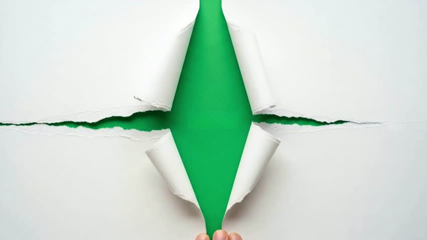 A hand tears and pulls back white paper to reveal a green screen background. Use this clean transition for logo reveals, titles, or dynamic video edits