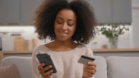 Carefree African American woman girl female shopping online with mobile phone and credit card buying in internet order payment successful paying with web money smartphone virtual banking using at home - Powered by Shutterstock - Get 15% off with code: PIKWIZARD15