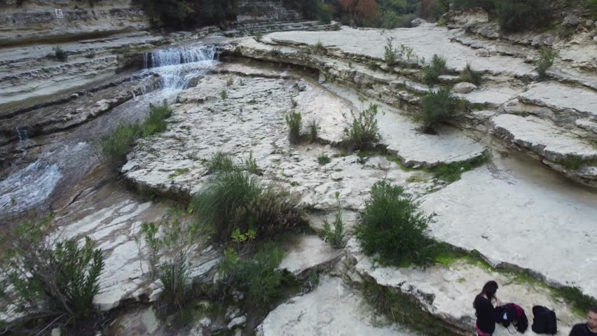 Cinematic 4K drone footage of the Laghetti di Cavagrande in Sicily, showcasing crystal-clear turquoise pools, dramatic canyon cliffs, and lush Mediterranean vegetation in a pristine natural setting.
