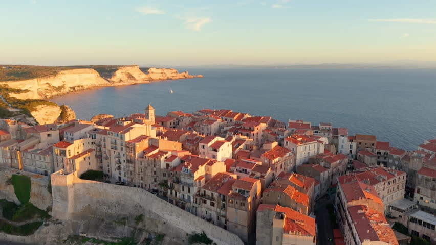 Aerial view of coastal sunset City, peaceful mediterranean coastal community with terracotta roofs during sunset. Bonifacio. France
