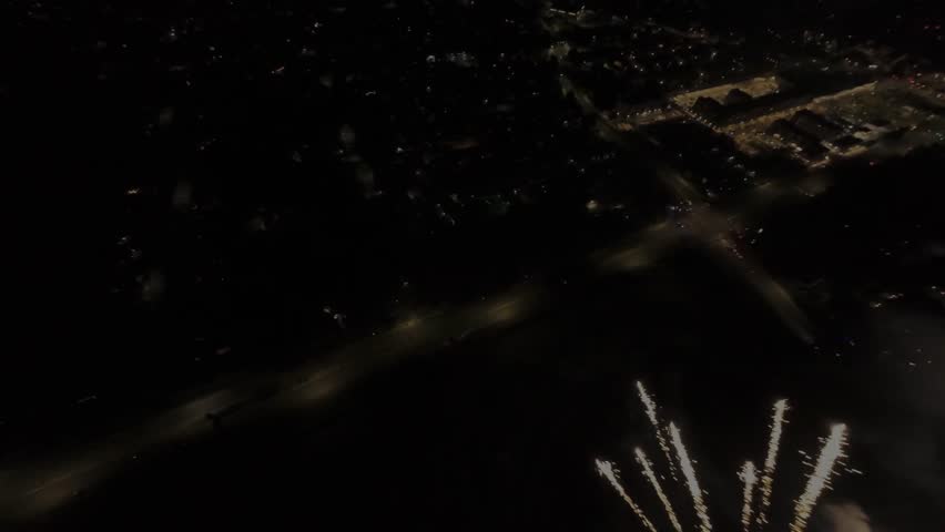 High-speed FPV drone footage flying through a barrage of fireworks launching from below.