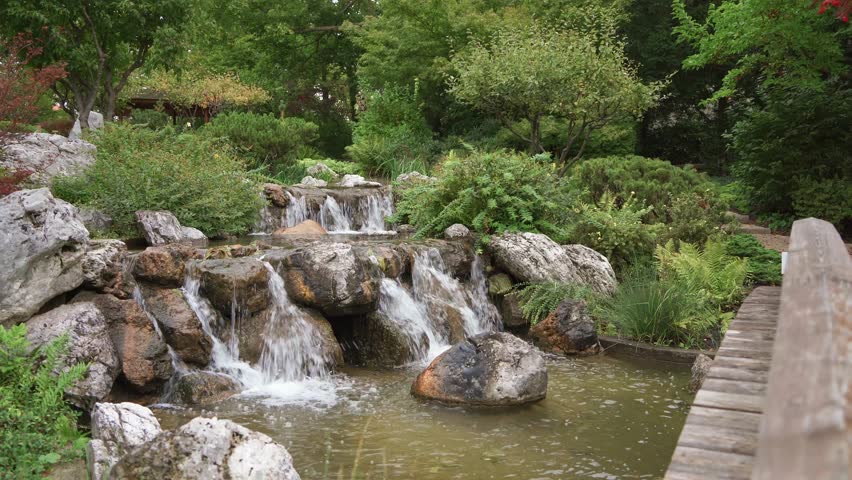Waterfall flowing through rocks in Setagayapark Japanese garden in Vienna, Austria.