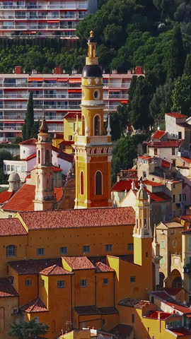  Aerial view of Menton, France. The colourful old town of Menton in summer, with historic buildings and beautiful beach at sunset. Aerial shot of historic church and colorful rooftops