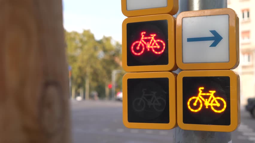 Close-up of bicycle traffic lights changing from red to Yellow in an urban environment in Barcelona, Spain. Sustainable transport and city cycling concept, 4K stock video.