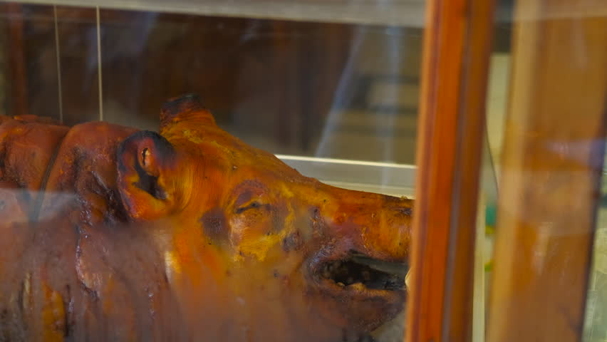 Roasted pig displayed in delicatessen window. Delicious roasted pig, expertly prepared and displayed in a delicatessen window, tempting passersby with its golden-brown skin and savory aroma