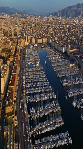  Many boats and yachts are parked in the city marina. Aerial view of the port of Marseille in the morning sun. Drone view of Marseille in the south of France