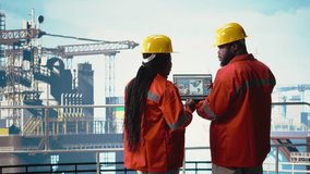 Drilling barge engineering team on deck studying geological maps to locate fossil fuel deposits. Offshore platform teamworking colleagues perform site assessment using digital mapping tech, camera A - Powered by Shutterstock - Get 15% off with code: PIKWIZARD15