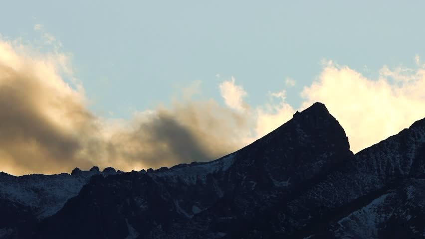 Winter Clouds passing over sierra nevada mountain peak in the shadows