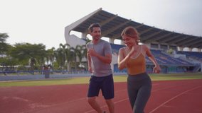 Diverse young man and woman athletes exercising together at stadium. Attractive sportswoman and male trainer running and work out for health activity, prepare for competition during training session. - Powered by Shutterstock - Get 15% off with code: PIKWIZARD15