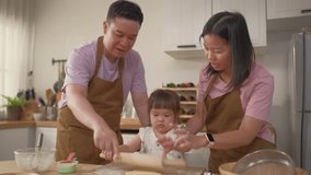 Asian mature parents lovingly care for and raises baby girl at home. Attractive couple shares tender moment teaching daughter toddler baking bakery in cozy kitchen, creating warm and nurturing family. - Powered by Shutterstock - Get 15% off with code: PIKWIZARD15