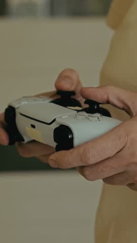 Close up video of hands of unrecognizable woman holding a joystick and playing video game.Vertical video