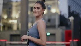 Young woman walks confidently through a modern city. She smiles at the camera, turns, walks away. City lights bokeh effect. Urban lifestyle, fashion, beauty. Stylish Woman Posing in Urban City Setting - Powered by Shutterstock - Get 15% off with code: PIKWIZARD15
