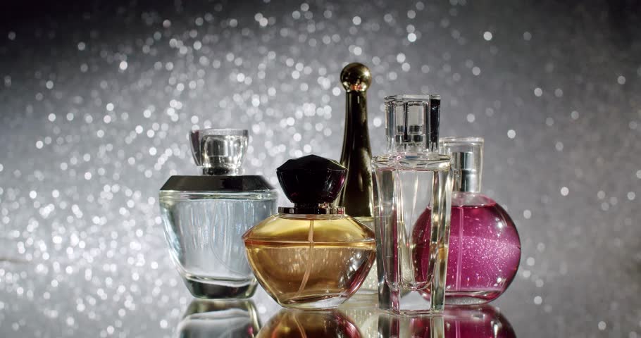 A collection of luxury perfume bottles displayed against a glittering background, showcasing elegance and sophistication. Perfect for concepts of beauty, fashion, and luxury. Beautiful Perfume Bottles