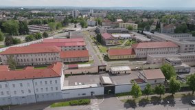 Aerial wide-to-medium push-in toward the prison entrance gate and security checkpoint; steady forward motion, continuous shot, daytime. - Powered by Shutterstock - Get 15% off with code: PIKWIZARD15