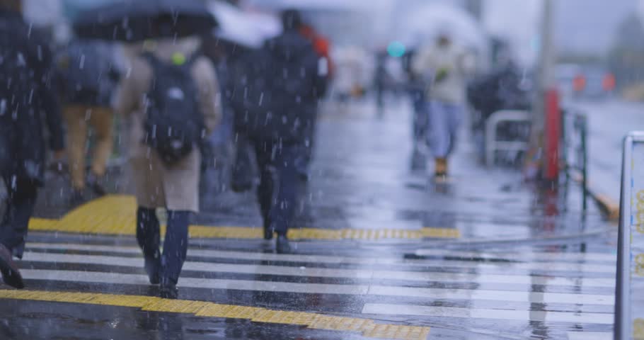 Walking office workers at business town in Shinjuku snowy day handheld