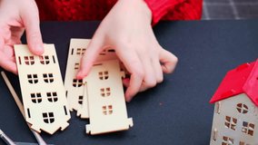 Unrecognizable woman in red sweater painting craft wooden houses for conscientious Merry Christmas decor. Sustainable celebration minimal responsible DIY holiday project. Step by step instruction - Powered by Shutterstock - Get 15% off with code: PIKWIZARD15