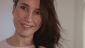 Millennial woman drying and styling her brunette hair with a hair dryer and a rotating brush. She smiles, sings, and dances in a bright minimalist bedroom. Concept of beauty, hairstyle, and self care. - Powered by Shutterstock - Get 15% off with code: PIKWIZARD15