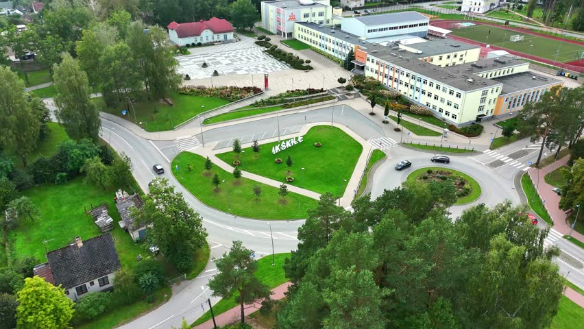 Aerial establish of entrance sign for Ikskile at intersection with urban green surroundings