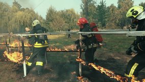 Firefighters in full gear run through a fiery obstacle course during intense training. Flames burst around as they demonstrate teamwork, bravery, and precision under extreme conditions. - Powered by Shutterstock - Get 15% off with code: PIKWIZARD15