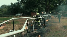 Firefighters in full gear run through a fiery obstacle course during intense training. Flames burst around as they demonstrate teamwork, bravery, and precision under extreme conditions. - Powered by Shutterstock - Get 15% off with code: PIKWIZARD15