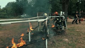 Firefighters in full gear run through a fiery obstacle course during intense training. Flames burst around as they demonstrate teamwork, bravery, and precision under extreme conditions. - Powered by Shutterstock - Get 15% off with code: PIKWIZARD15