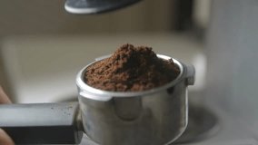 Closeup of espresso grounds being added to portafilter, highlighting the rich, dark textures and fresh coffee aromas, setting the stage for a perfect brew experience. - Powered by Shutterstock - Get 15% off with code: PIKWIZARD15