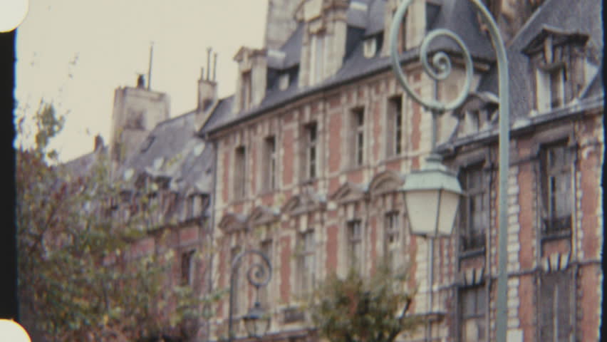 Facade of Maison de Victor Hugo in Paris viewed from the street, with parked cars in front, captured on 8mm film.