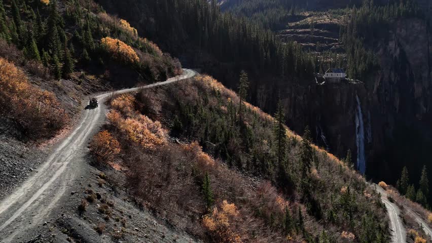 Aerial view of Bridal Veil Falls cascading down the cliff face with trees displaying autumn colors, Telluride, Colorado, United States.