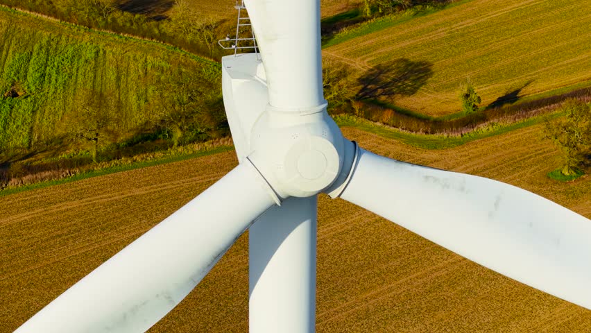 Large rotor wind electric generator. Wind turbine rotating energy blades to deliver carbon neutral power. Spinning energy blades supplying green electricity on wind farm