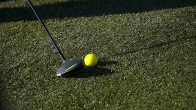 Golfer stands near bright yellow golf ball on pristine green grass, ready to swing club in perfect weather. Captures the essence of the sport and outdoor leisure activity. - Powered by Shutterstock - Get 15% off with code: PIKWIZARD15