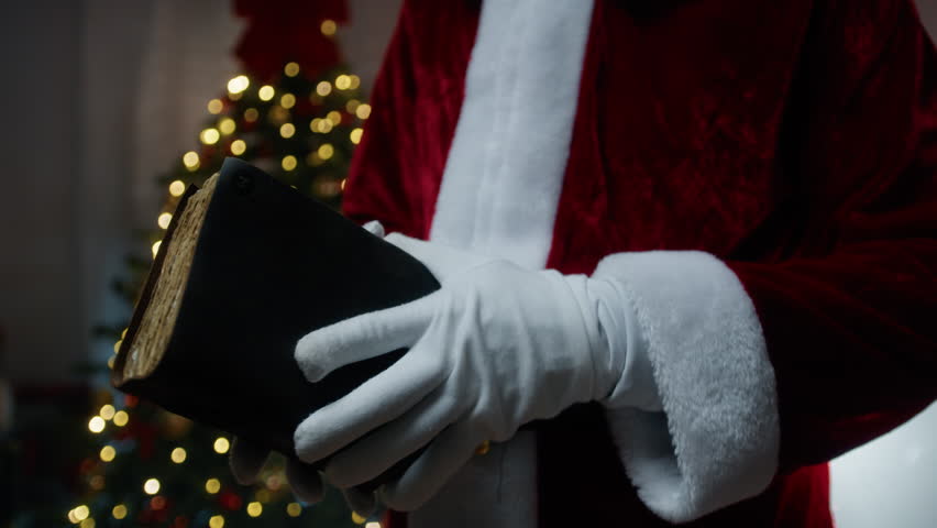 Santa Claus opening an old book in search of informations 