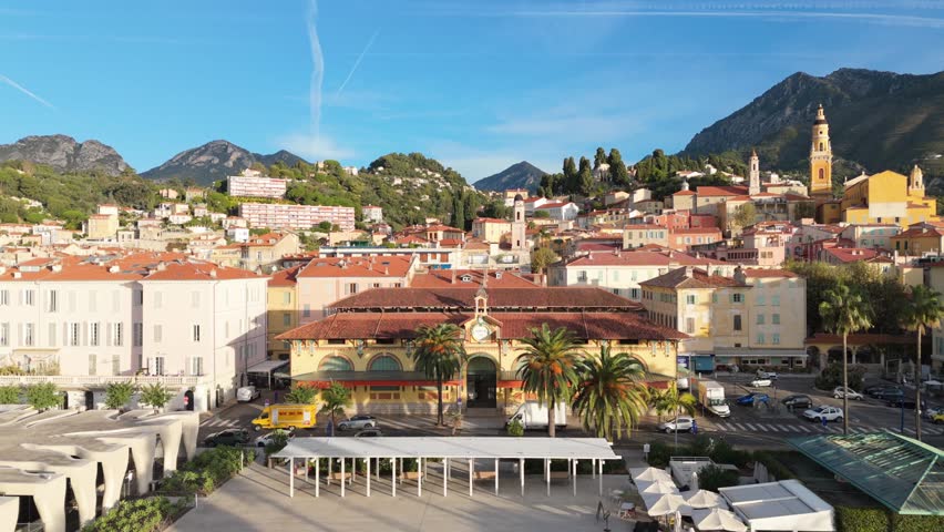 Scenic view of the old market building on the main square in Menton, a charming town on the French Riviera. Historic architecture, colorful facades, and Mediterranean atmosphere under bright sunlight.