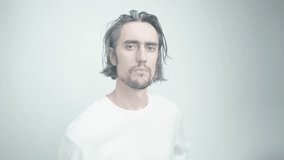 Arrogant Gift: Quirky Man with Long Hair and Beard in White Sweater Presenting Red Roses on Minimalistic Background - Powered by Shutterstock - Get 15% off with code: PIKWIZARD15