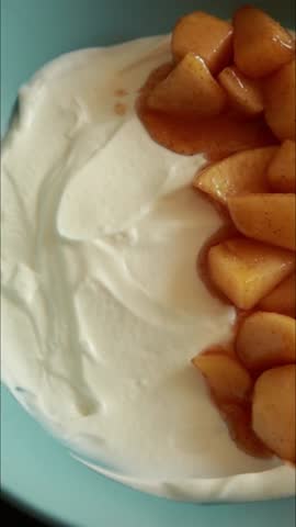 close up of preparing yogurt bowl with caramelized apples and granola
