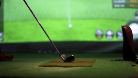 Indoor golf practice environment features a player preparing to swing a driver at a simulated golf course displayed on a screen. - Powered by Shutterstock - Get 15% off with code: PIKWIZARD15