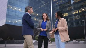 Diverse business colleagues talking outdoors near modern office buildings - Powered by Shutterstock - Get 15% off with code: PIKWIZARD15