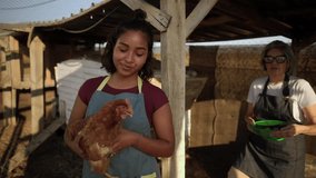 Smiling generational female farmers posing for a portrait in a rustic chicken coop, with the younger woman holding a hen and the older woman carrying a basket of freshly collected eggs - Powered by Shutterstock - Get 15% off with code: PIKWIZARD15