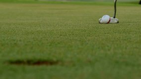 Close-up view of a golfer preparing to putt on lush green grass of a golf course. Focus on the ball resting near the hole, capturing the excitement of the game. - Powered by Shutterstock - Get 15% off with code: PIKWIZARD15