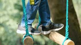 Child carefully navigates a rope bridge obstacle course in an outdoor adventure park - Powered by Shutterstock - Get 15% off with code: PIKWIZARD15