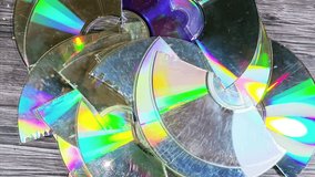 Several broken compact discs CDs that display a rainbow-like effect known as iridescence, a CD is digital optical disc data storage format, to store and play digital audio and video recordings - Powered by Shutterstock - Get 15% off with code: PIKWIZARD15