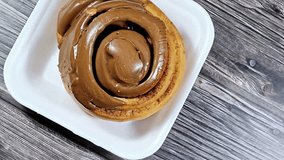a chocolate cinnamon roll, a type of sweet roll or pastry that made of rolled dough with a cinnamon and sugar mixture then topped with chocolate glaze or frosting, popular in North Europe and America - Powered by Shutterstock - Get 15% off with code: PIKWIZARD15