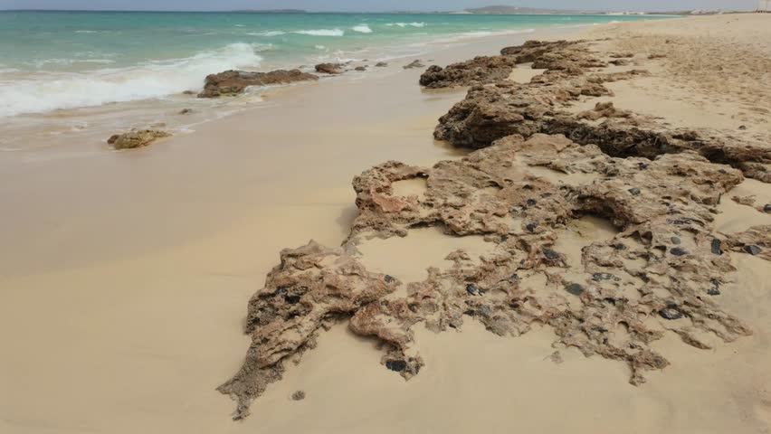 Atlantic Ocean waves breaking over a volcanic rock shoreline of the Cape Verde island of Boa Vista.