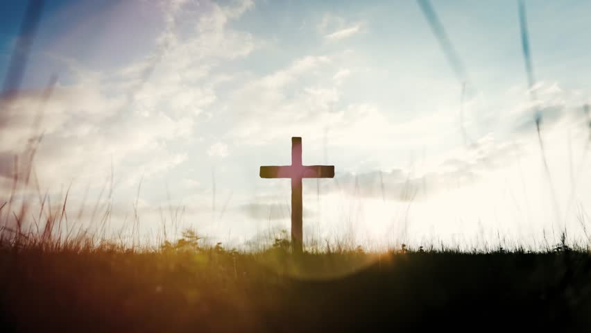 Wooden cross silhouette against sunset sky, representing christianity, faith, and hope