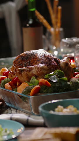 Vertical video camera moving over festive table people serving salad pouring wine carving turkey background cozy light thanksgiving christmas celebration gratitude home warmth