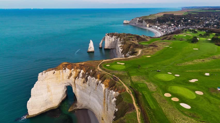 Aerial drone view of picturesque coastal limestone cliffs and the English Channel town of Etretat, France. High quality 4k footage