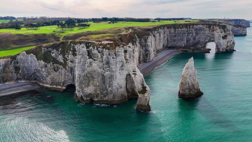 Aerial drone view of picturesque coastal limestone cliffs and the English Channel town of Etretat, France. High quality 4k footage