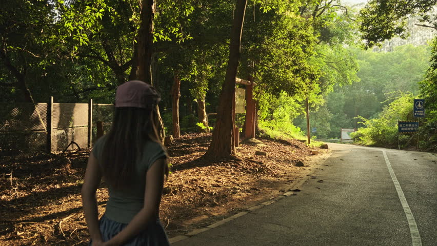 A Cinematic Shot of a Beautiful Woman Walking on a Park Path, Capturing a Quiet, Serene, and Relaxing Afternoon Moment (ProRes 422) Chinese content：Construction vehicles should slow down.