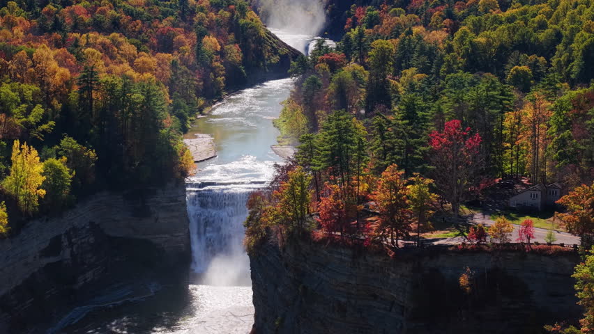 Scenic aerial view of Letchworth State Park canyon near Rochester, New York, with a majestic waterfall surrounded by autumn forest. High quality 4k footage